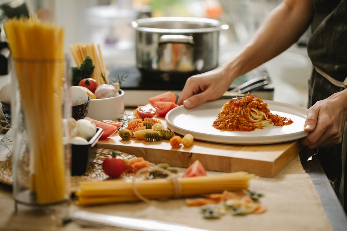 Home cook preparing pasta to explore world cuisine at home using simple ingredients.