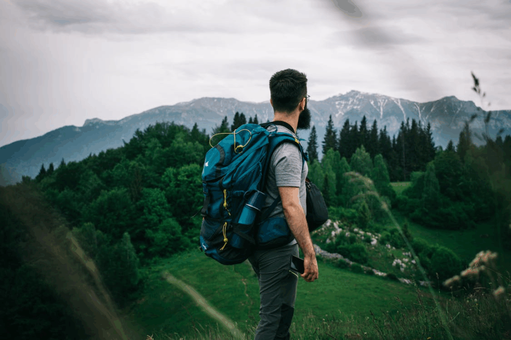 Man hiking through mountains while planning a $20 day trip.