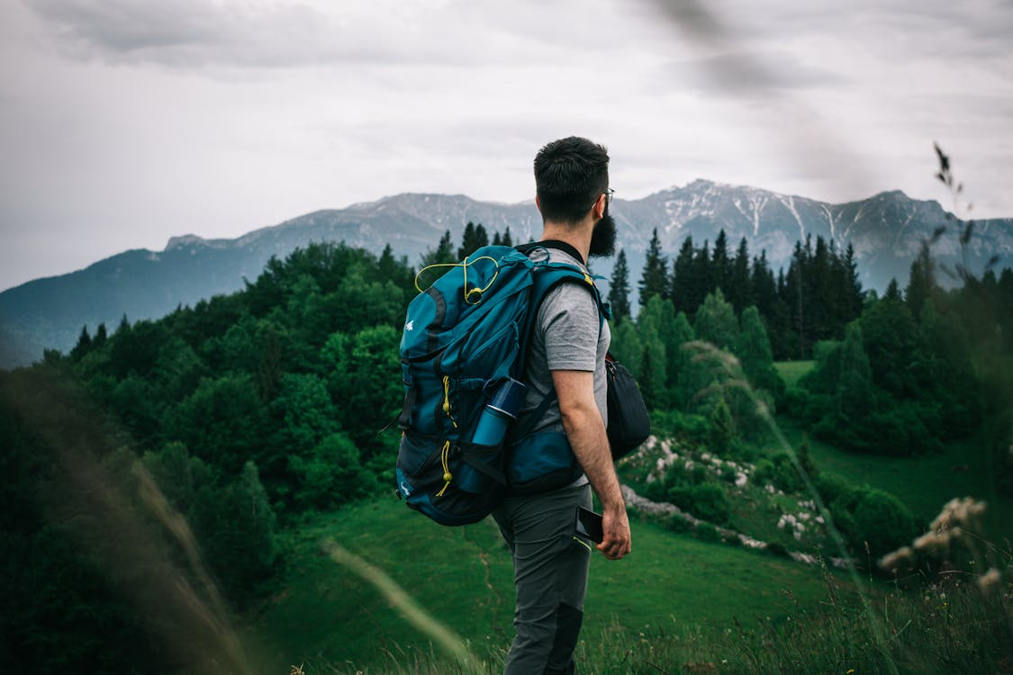 Man hiking through mountains while planning a $20 day trip.