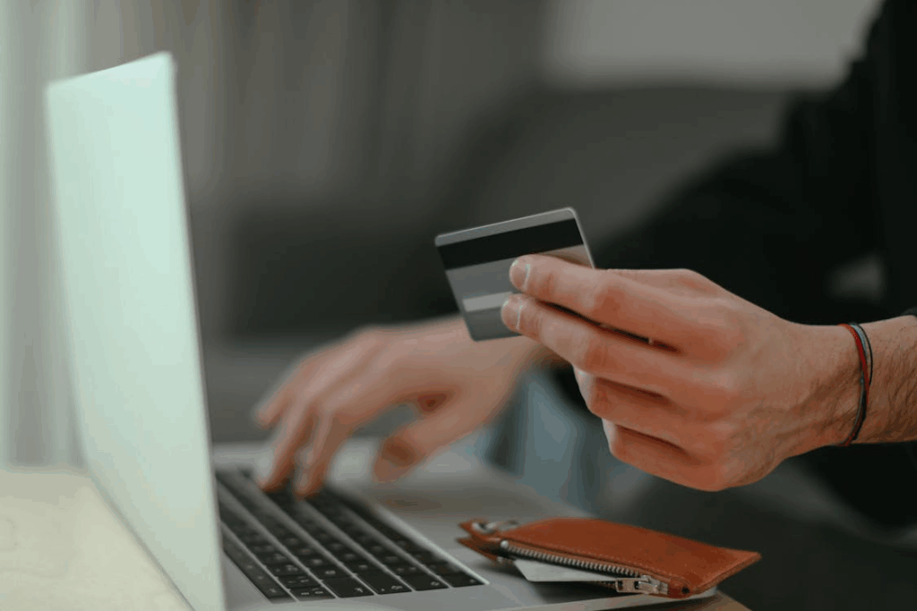 Person holding a credit card while using the one more day rule before buying.