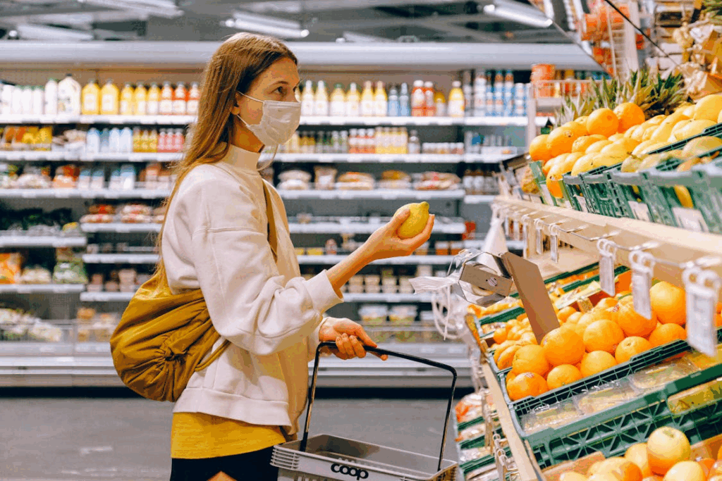 Woman shopping in a brightly lit grocery aisle, influenced by store layout and product choices.